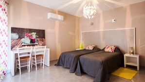 Un dormitorio moderno con dos camas, un escritorio y una mesa de comedor.