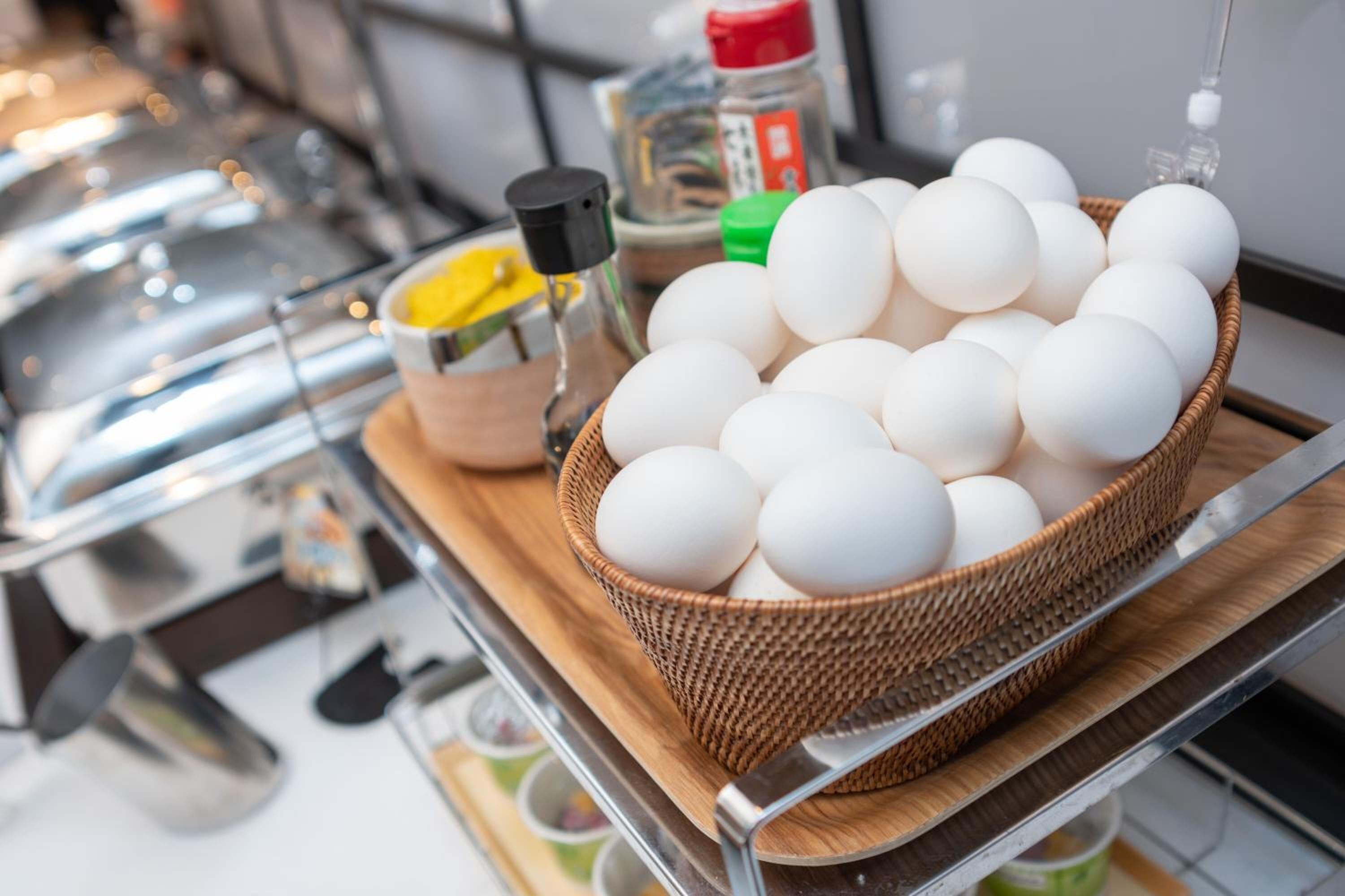 A basket of eggs on a wooden board in a kitchen setting.