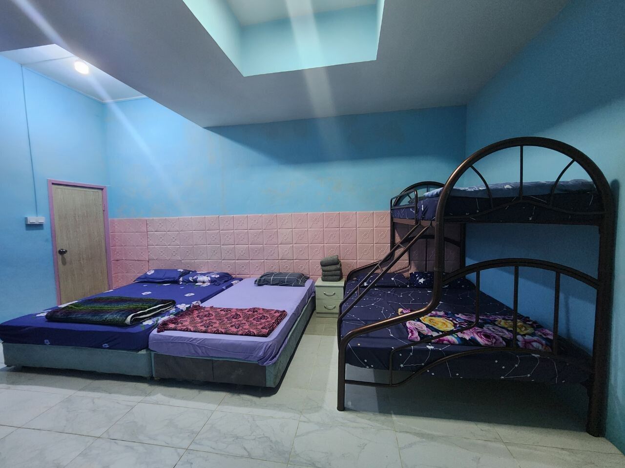 Una habitación con dos literas, una ventana pequeña y una puerta.