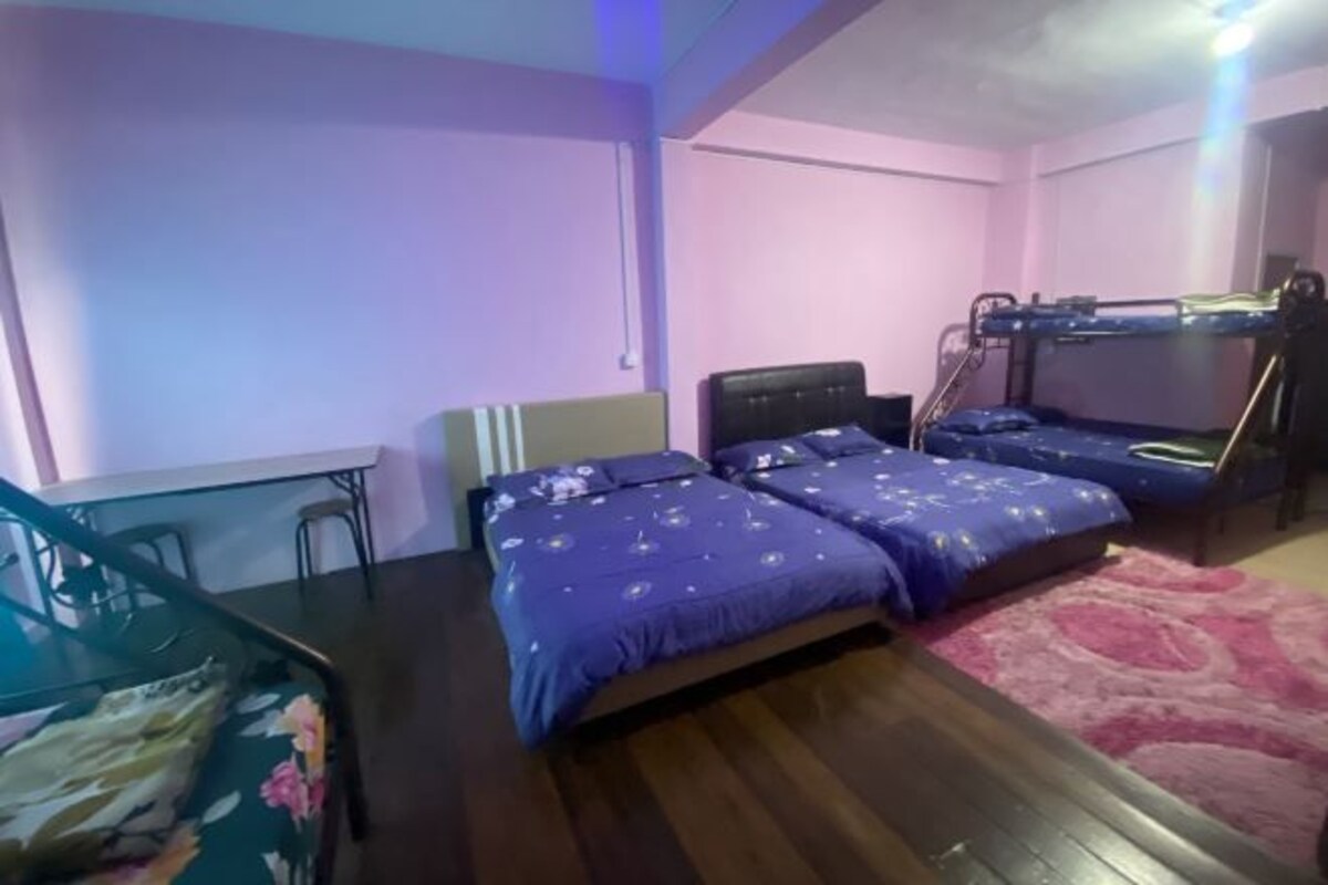 A room with bunk beds, a desk, and a chair.