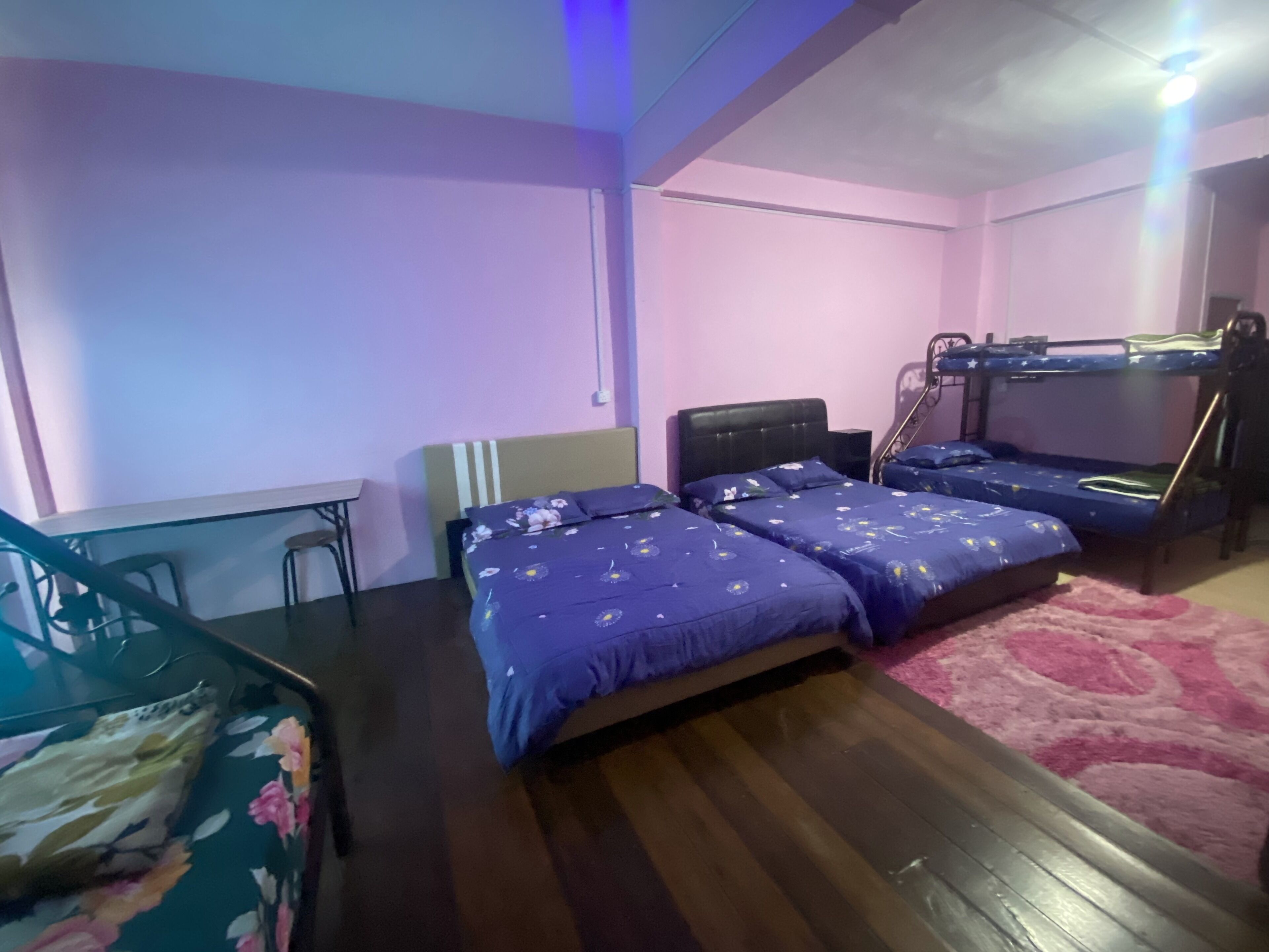 A bedroom with two beds, a bunk bed, a desk, and a chair.