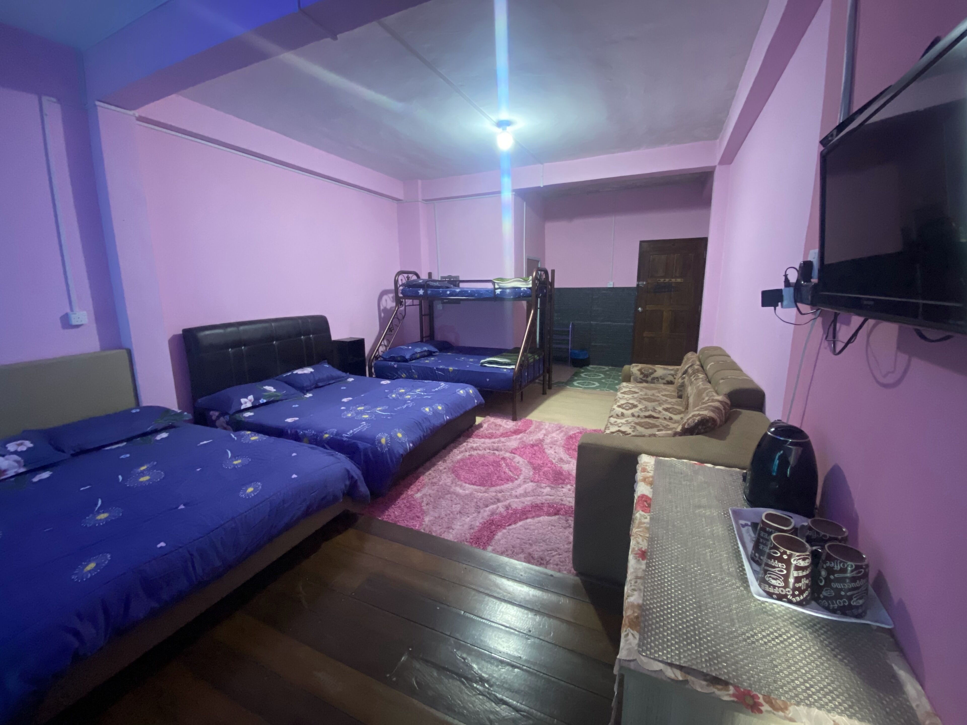 A room with bunk beds, a sofa, a coffee table, and a TV.