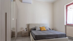 A bedroom with a bed, bedside table, and a wardrobe. - Manzoni Apartment (Roseto degli Abruzzi)
