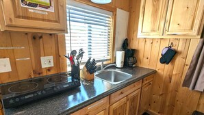 A kitchen with wooden cabinets, a stainless steel sink, and a built-in induction cooktop. - Yellowstone's Treasure Cabin #6, few min drive from Yellowstone Park (Gardiner)