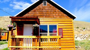 Eine Holzhütte mit Balkon, Fenster und Tür.