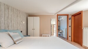 A bedroom with a bed, a wardrobe, a small table, and a chair.