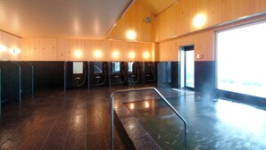 A public sauna with wooden walls, multiple benches, and a glass barrier over the hot tub. - Matsudai Shibatoge Onsen Unkai (Tokamachi)