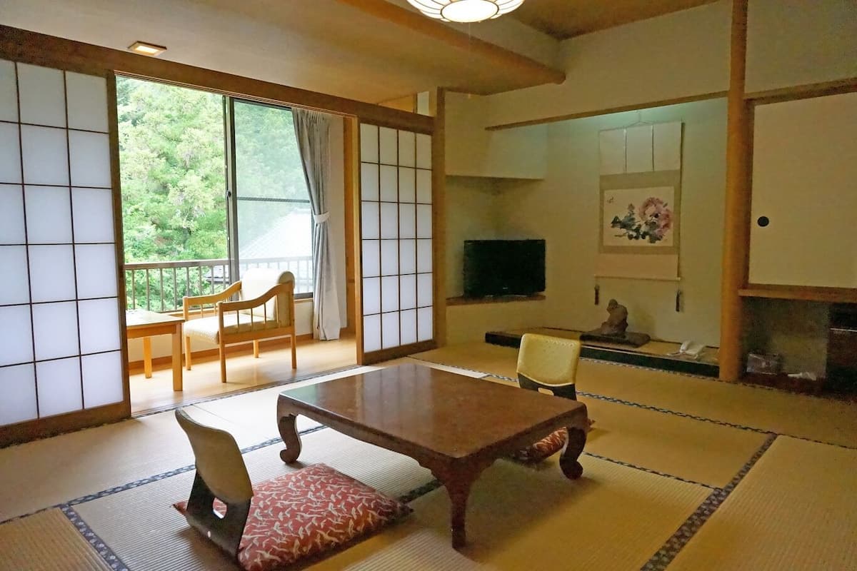 Et traditionelt japansk værelse med tatamimåtter, et lavt bord og skydedøre.