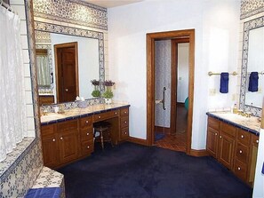 A bathroom with a double vanity, a large mirror, and a door leading to another room. - Large Family  On Adams Avenue - Ski In/out 5 Bedroom Home by RedAwning (Snowmass Village)