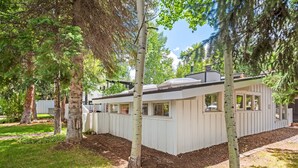 A modern house with a white exterior, surrounded by trees and a well-maintained lawn. - Aspen West End  - Quiet Neighborhood 3 Bedroom Home by RedAwning (Aspen)