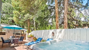 A hot tub surrounded by lounge chairs and a dining area with outdoor furniture. - Aspen West End  - Quiet Neighborhood 3 Bedroom Home by RedAwning (Aspen)