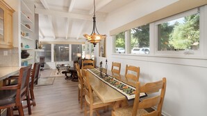 A dining area with a long wooden table, chairs, and a hanging light fixture. - Aspen West End  - Quiet Neighborhood 3 Bedroom Home by RedAwning (Aspen)
