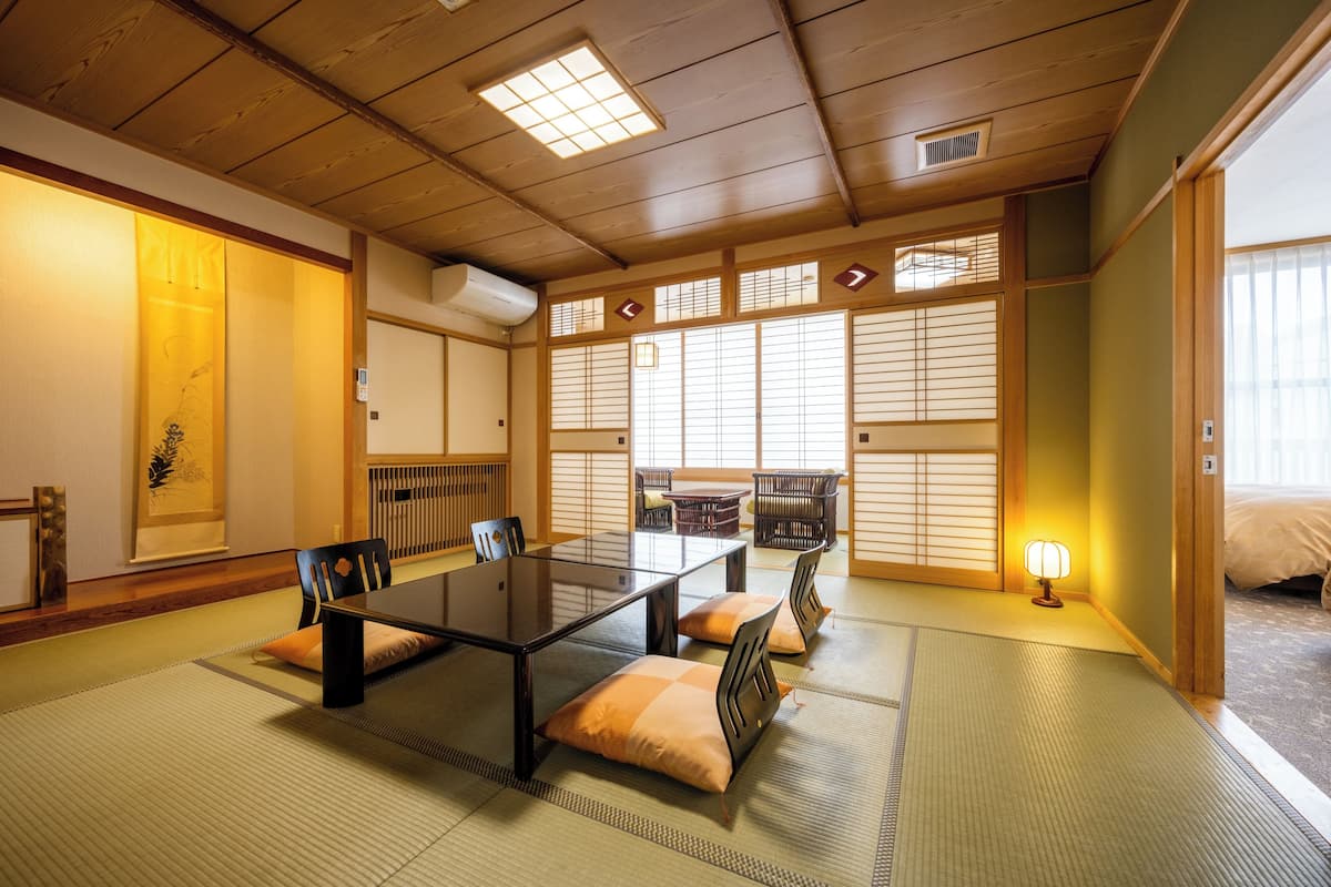 A traditional Japanese room with tatami flooring, a low table, and sliding doors.