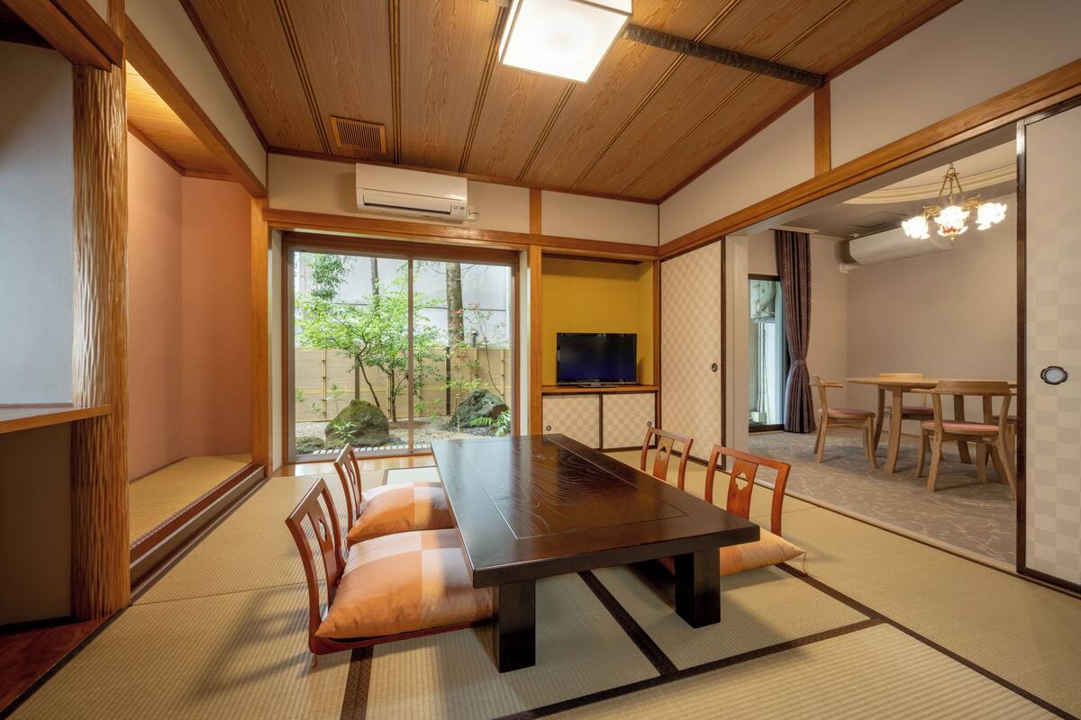 Een traditionele Japanse kamer met tatami vloeren, een lage tafel en een televisietoestel.