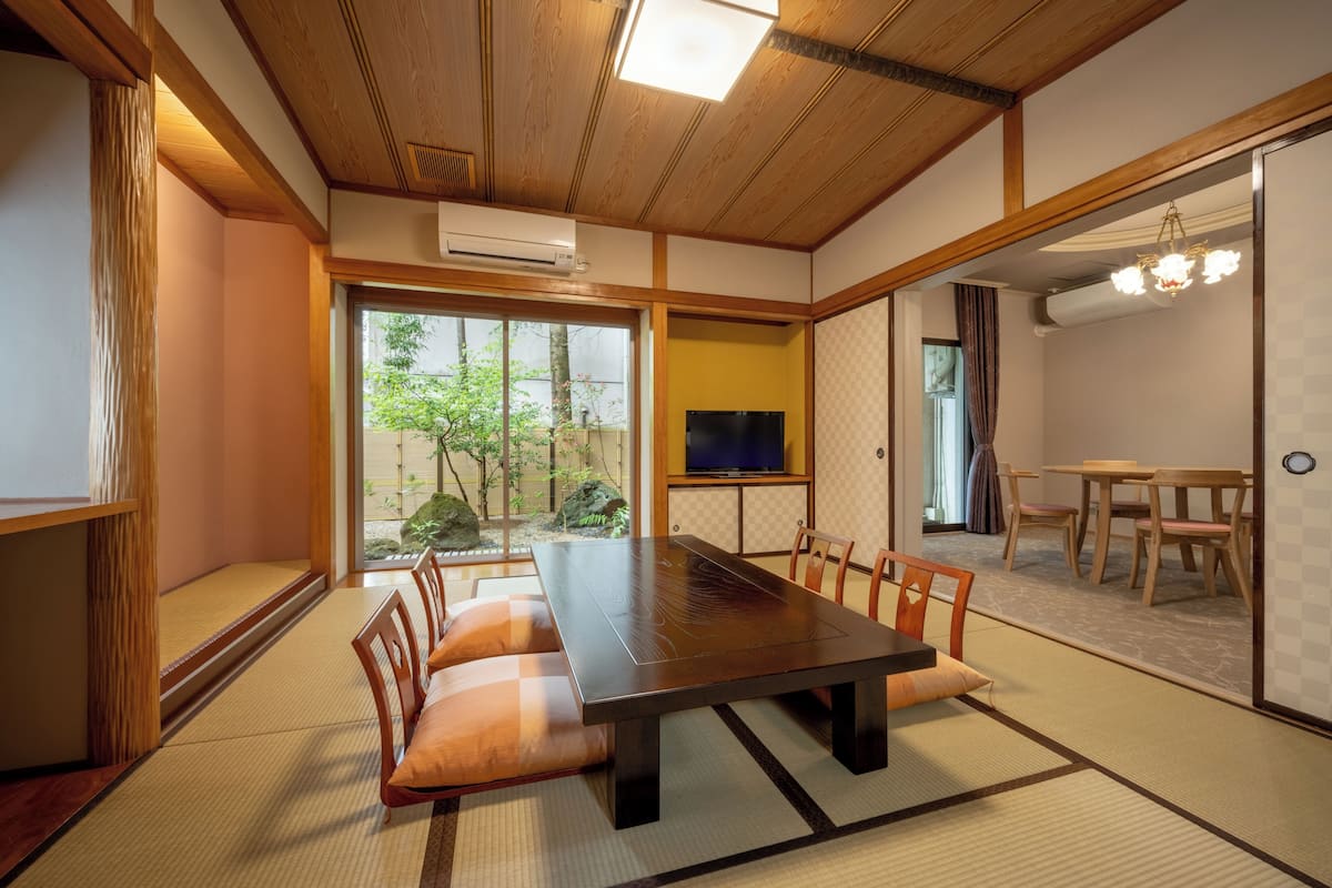 A traditional Japanese-style room with tatami flooring, a low table, and a television.