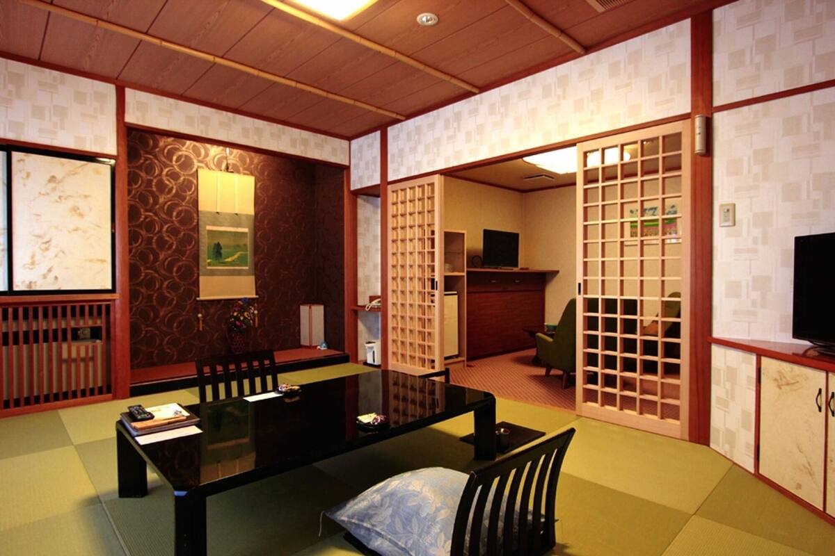 Een traditionele Japanse kamer met tatami vloeren, een lage tafel en shoji schermen.