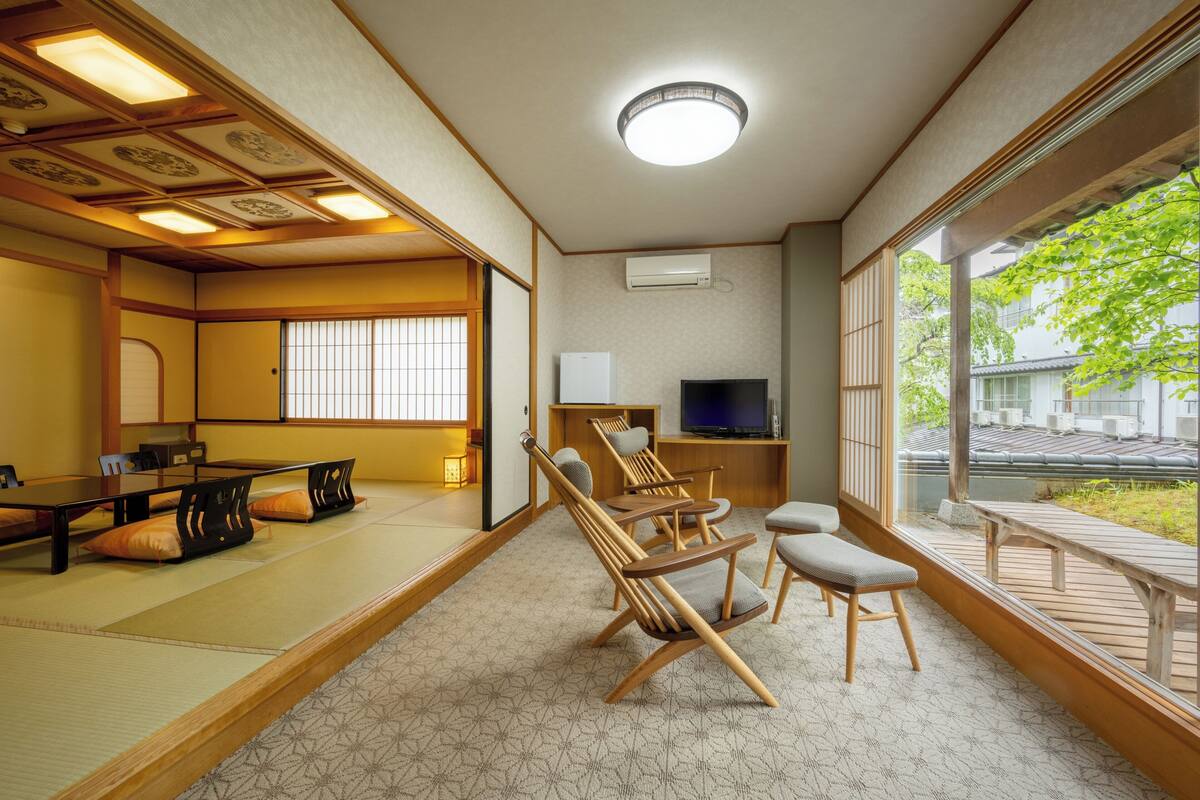 Een traditionele Japanse kamer met tatami vloerbedekking, een lage tafel en houten stoelen.
