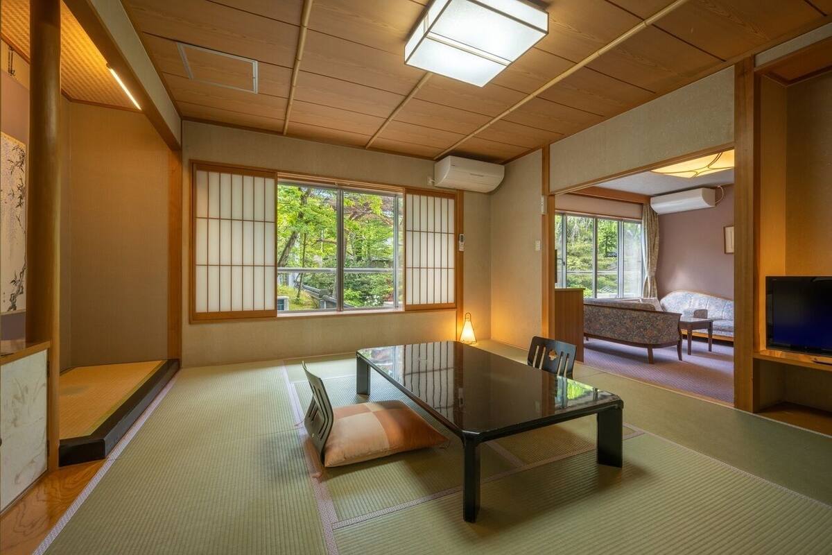 Een traditionele Japanse kamer met tatami vloeren, een lage tafel en schuifdeuren.