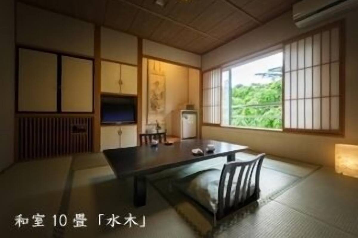 Een traditionele Japanse kamer met tatami vloeren, een lage tafel en schuifdeuren.
