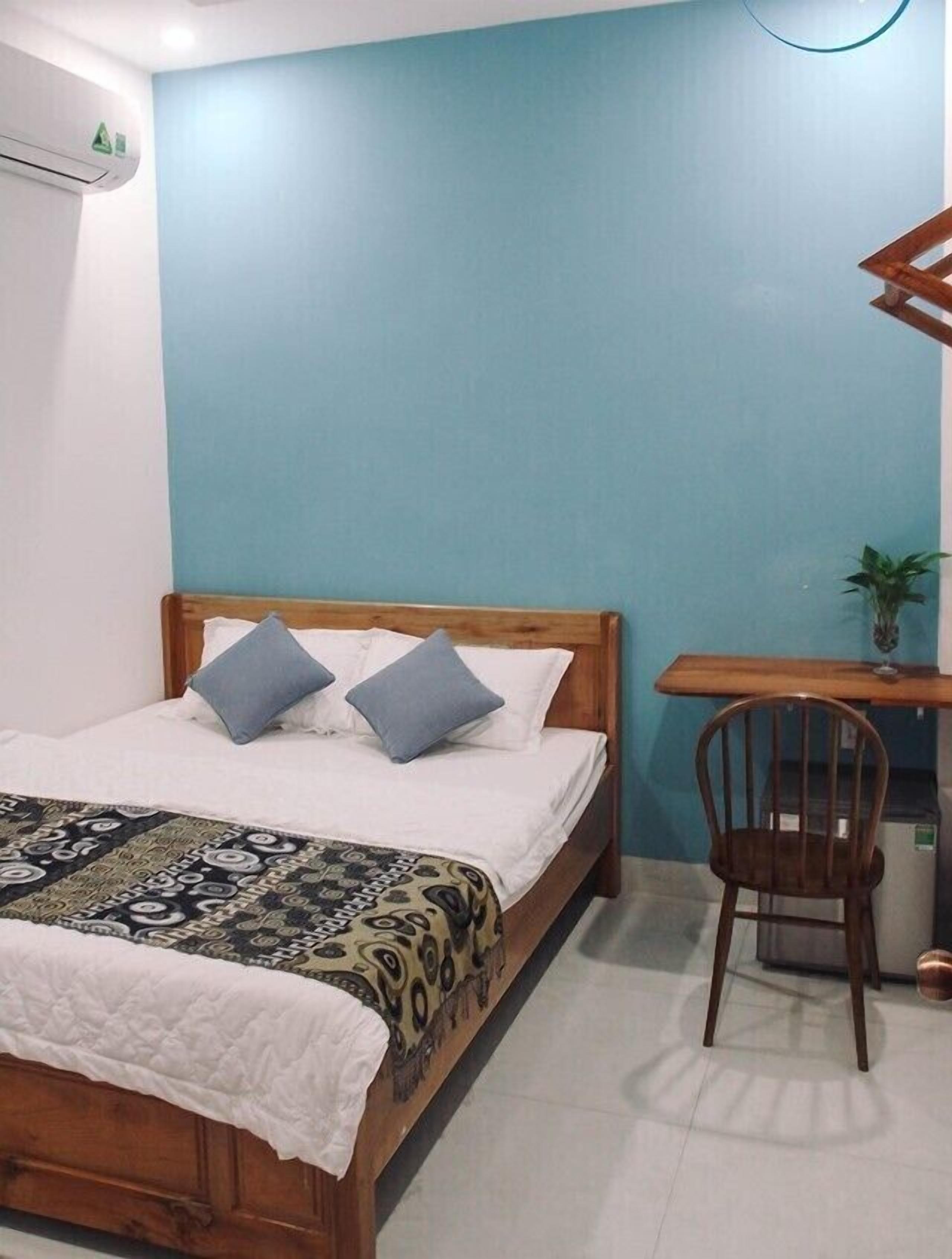 A bedroom with a wooden bed, a desk, and a chair.