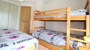 A bunk bed room with two beds, a wardrobe, and a door. - Ground floor, balcony, tv, ski locker, 43m², Val Cenis (Lanslevillard)