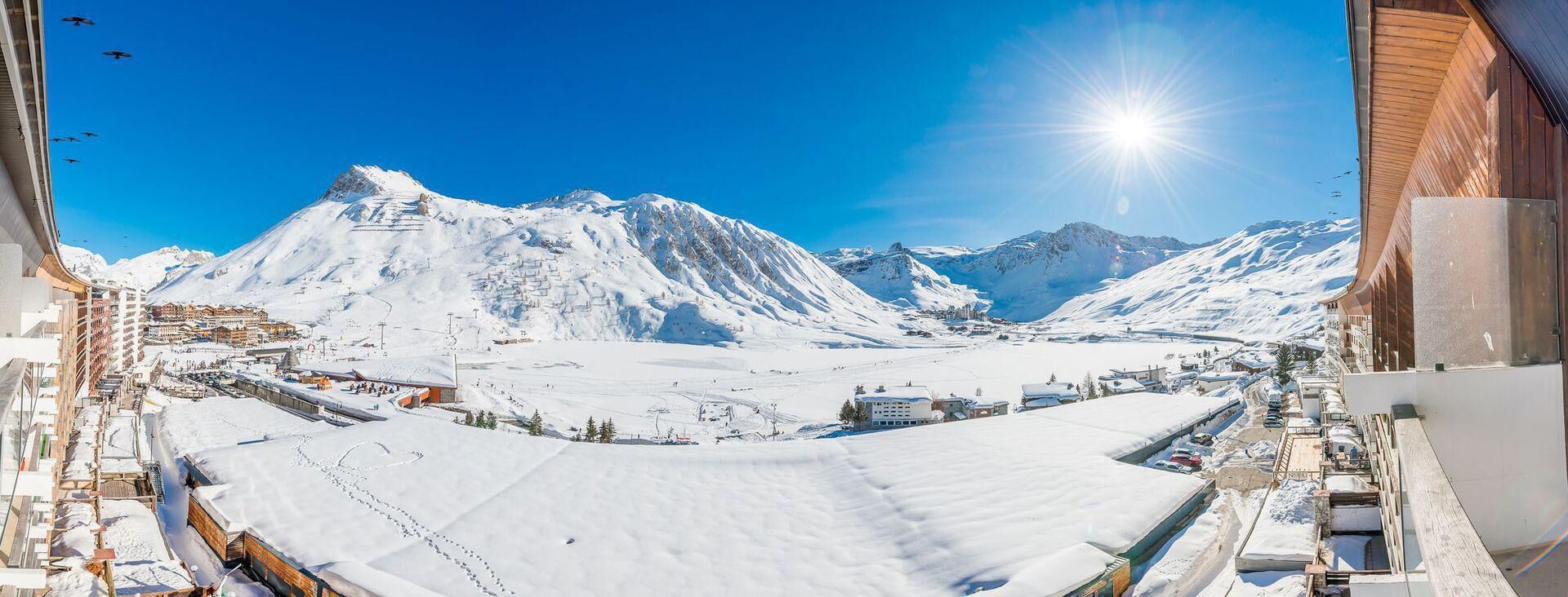 Schneebedeckte Berglandschaft mit einem Skigebiet, einschließlich Skipisten und Gebäuden.