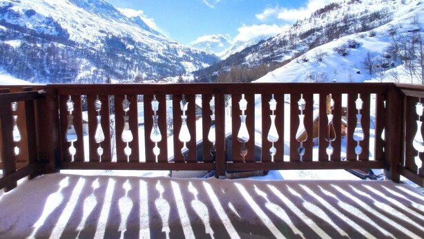 A wooden balcony with a view of snow-covered mountains under a clear sky. - 4th floor, swimming pool, balcony, tv, ski locker, 46m², Valloire (Valloire)
