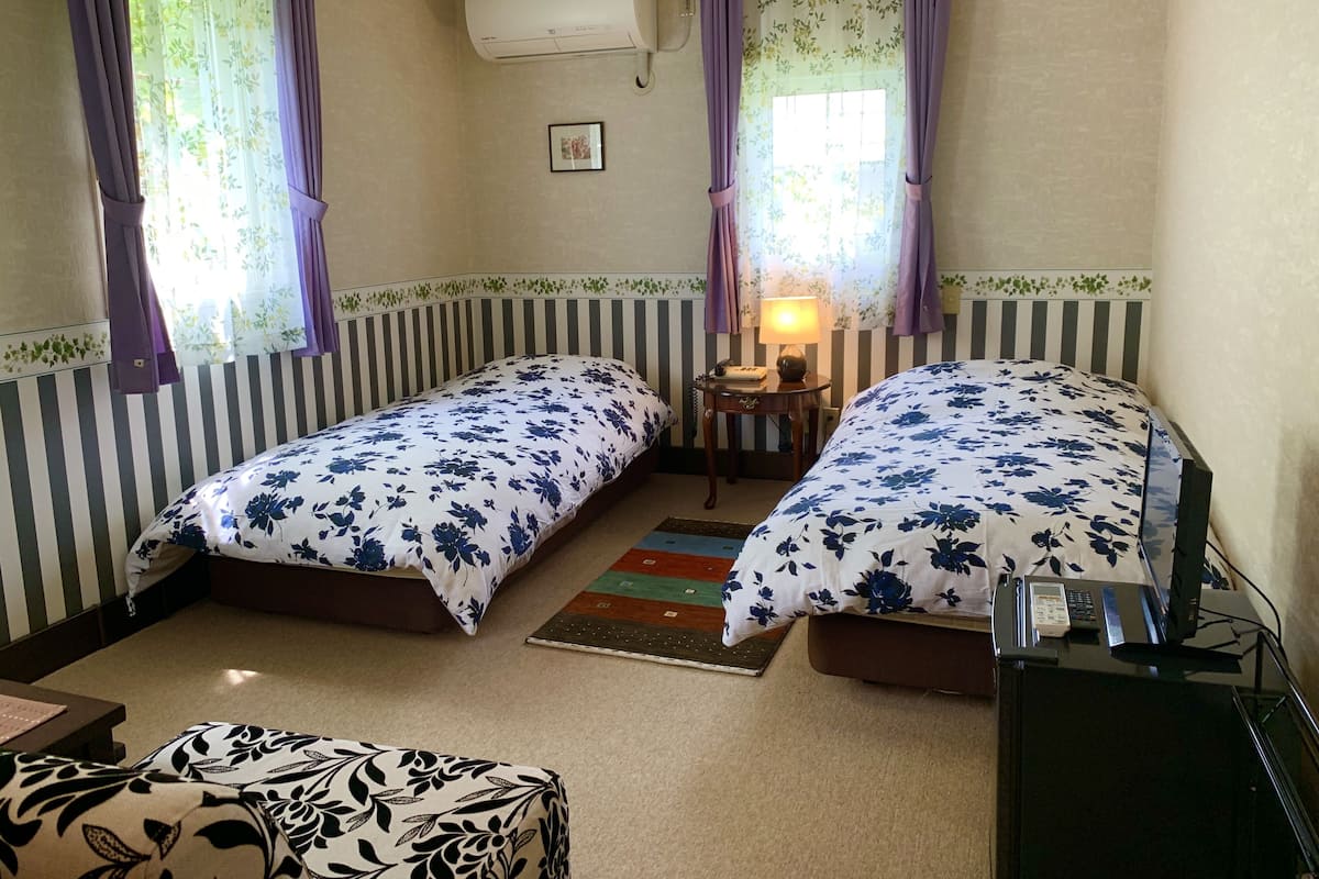 Habitación con 2 camas individuales, en esquina | Tabla de planchar con plancha