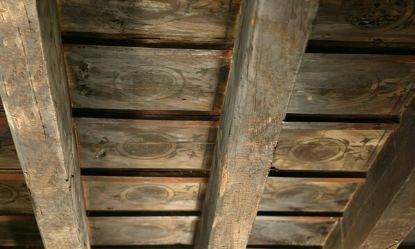Teto de madeira com padrão em grade, provavelmente parte da estrutura de um edifício.