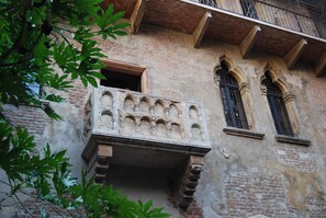 A historic building with a balcony, arched windows, and brick walls. - Residenza San Faustino (Verona)
