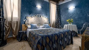 A bedroom with a large bed, a nightstand, a table with a vase, and a chair. - Residenza San Faustino (Verona)