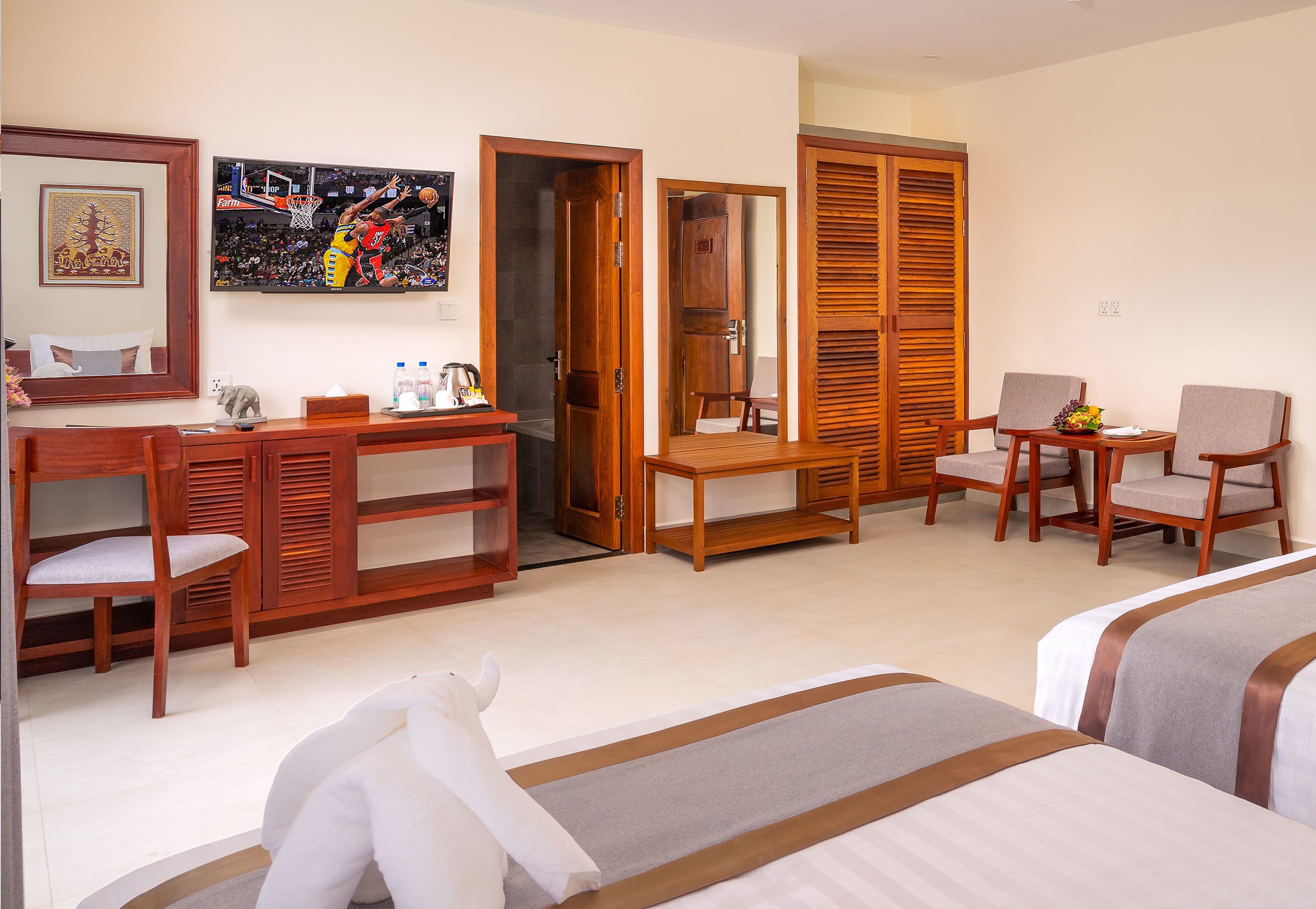 Una habitación de hotel con cama, escritorio, silla, mesita y armario.