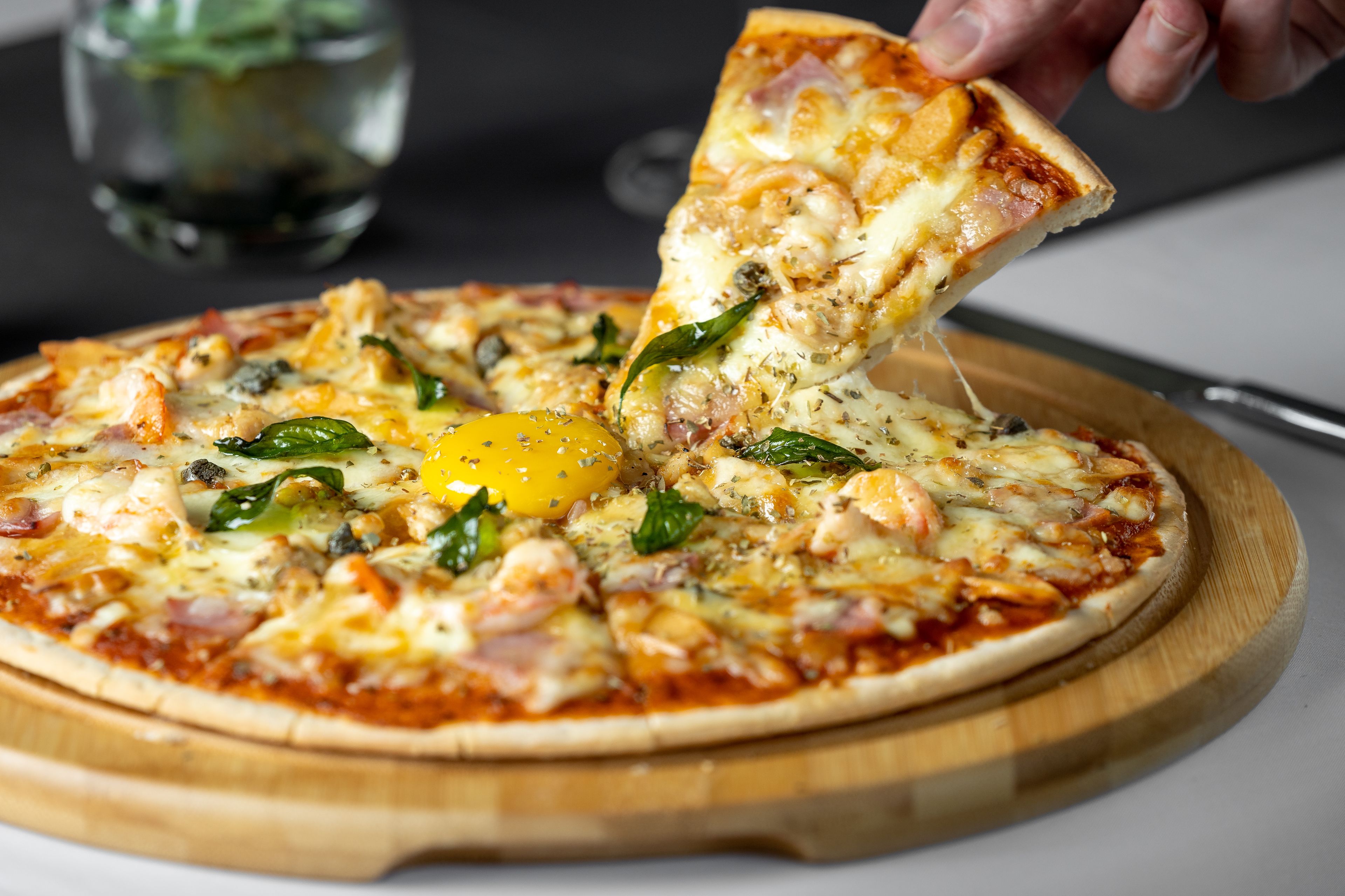 A pizza with various toppings on a wooden board.