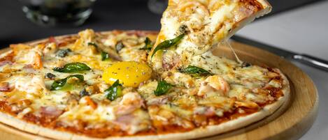A pizza with various toppings on a wooden board.