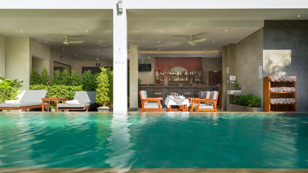Ein Hallenbad mit Liegestühlen und einer Bar.