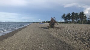 A pebbled beach with boats and palm trees. - Villa Catalina Bora Resort (Nabas)