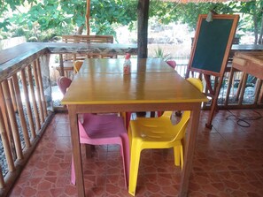 A wooden table with a green chalkboard, surrounded by chairs and a bench. - Villa Catalina Bora Resort (Nabas)