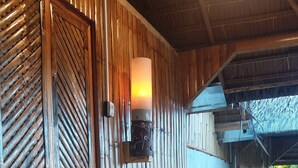 A wooden interior with a door, a wall-mounted light, and a wooden bench. - Villa Catalina Bora Resort (Nabas)