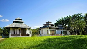 Een traditioneel Japans gebouw met een pannendak en een kleine tuin ervoor.
