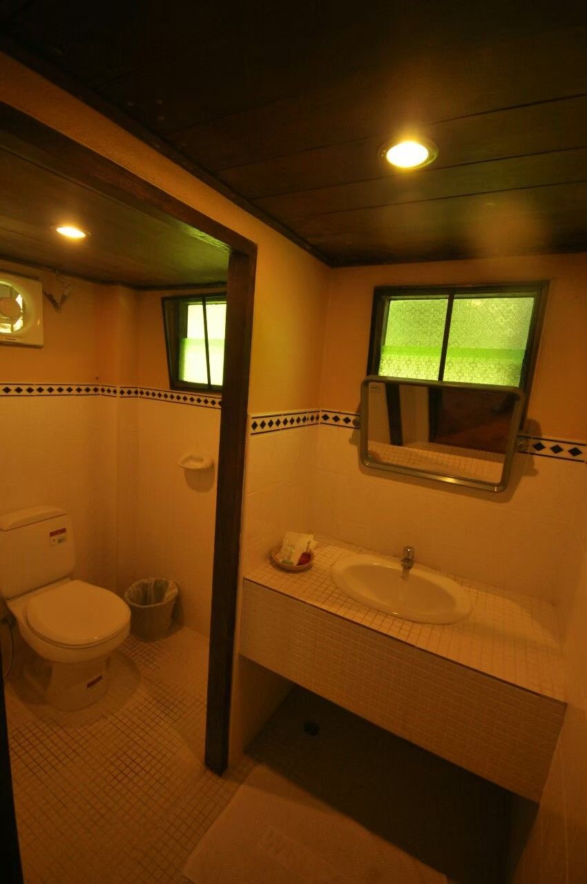 A bathroom with a toilet, sink, and mirror.