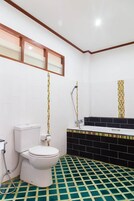 Un baño con inodoro, ducha y lavamanos.