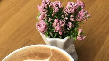 A cup of coffee with latte art on a wooden coaster.
