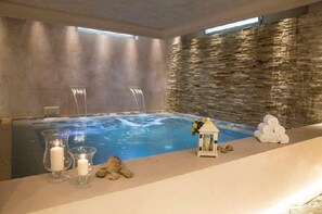A spa area with a hot tub, candles, and towels. - Relais Pugliano (Castelfiorentino)