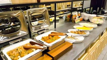 En buffé med ett varierat utbud av mat och serveringsredskap.