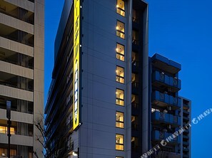 A multi-story building with balconies and a prominent yellow sign. - Super Hotel Kuwana-ekimae (Kuwana)