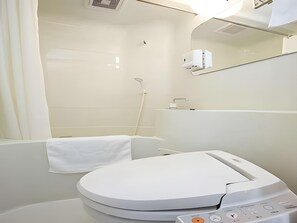 A modern bathroom with a toilet, a shower, and a mirror.