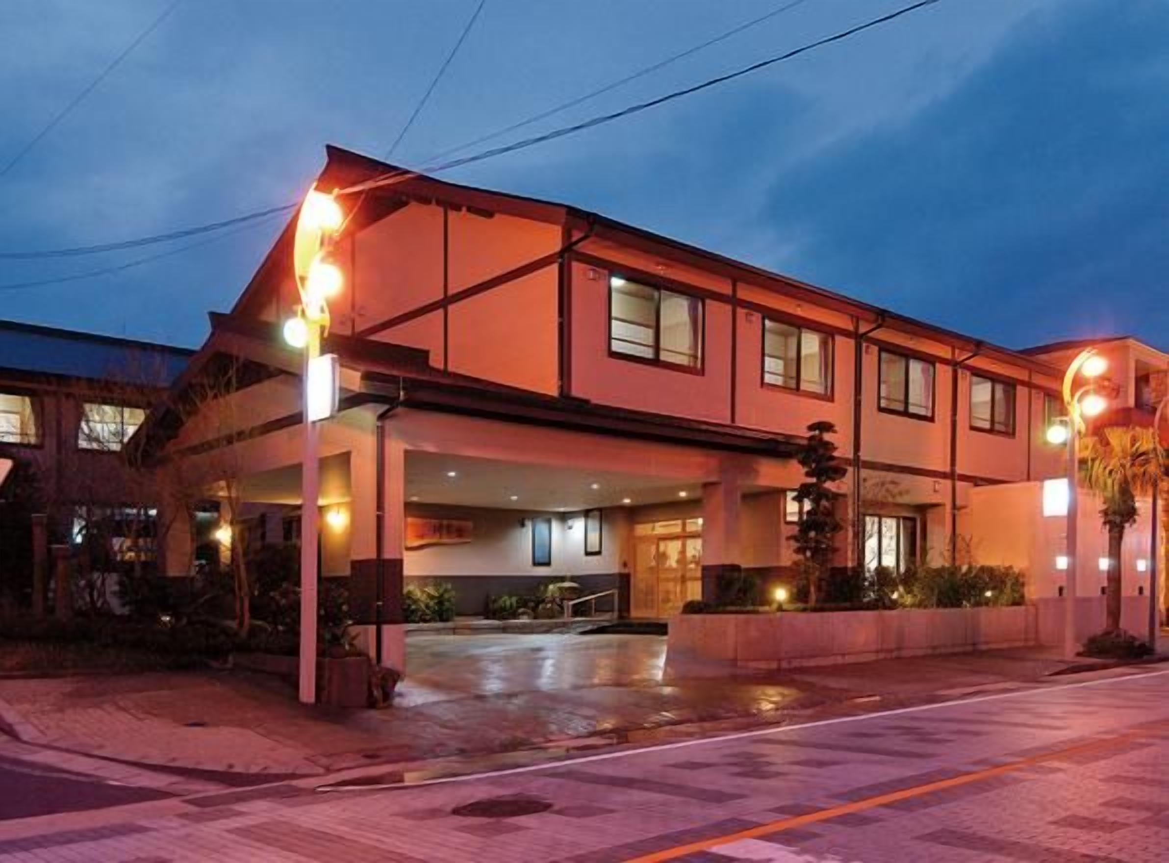 A two-story building with a covered entrance and a visible outdoor area.