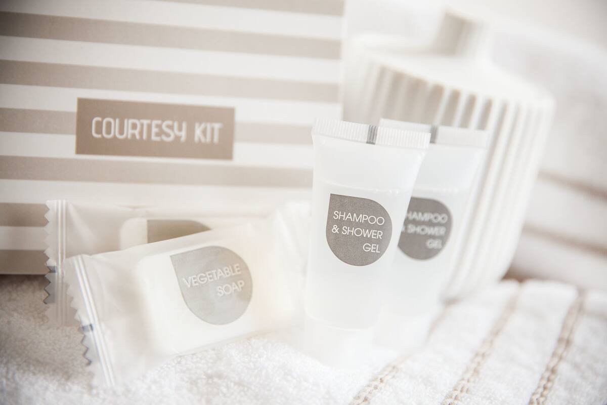 Toiletries including shampoo, shower gel, and vegetable soap in a toiletry kit.