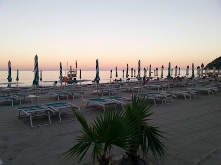 Playa privada, sillas reclinables de playa, sombrillas, bar en la playa