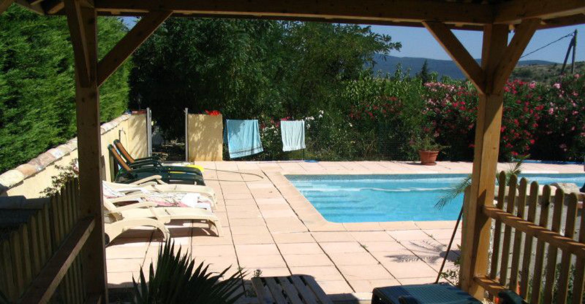 A pool area with lounge chairs and a pergola.